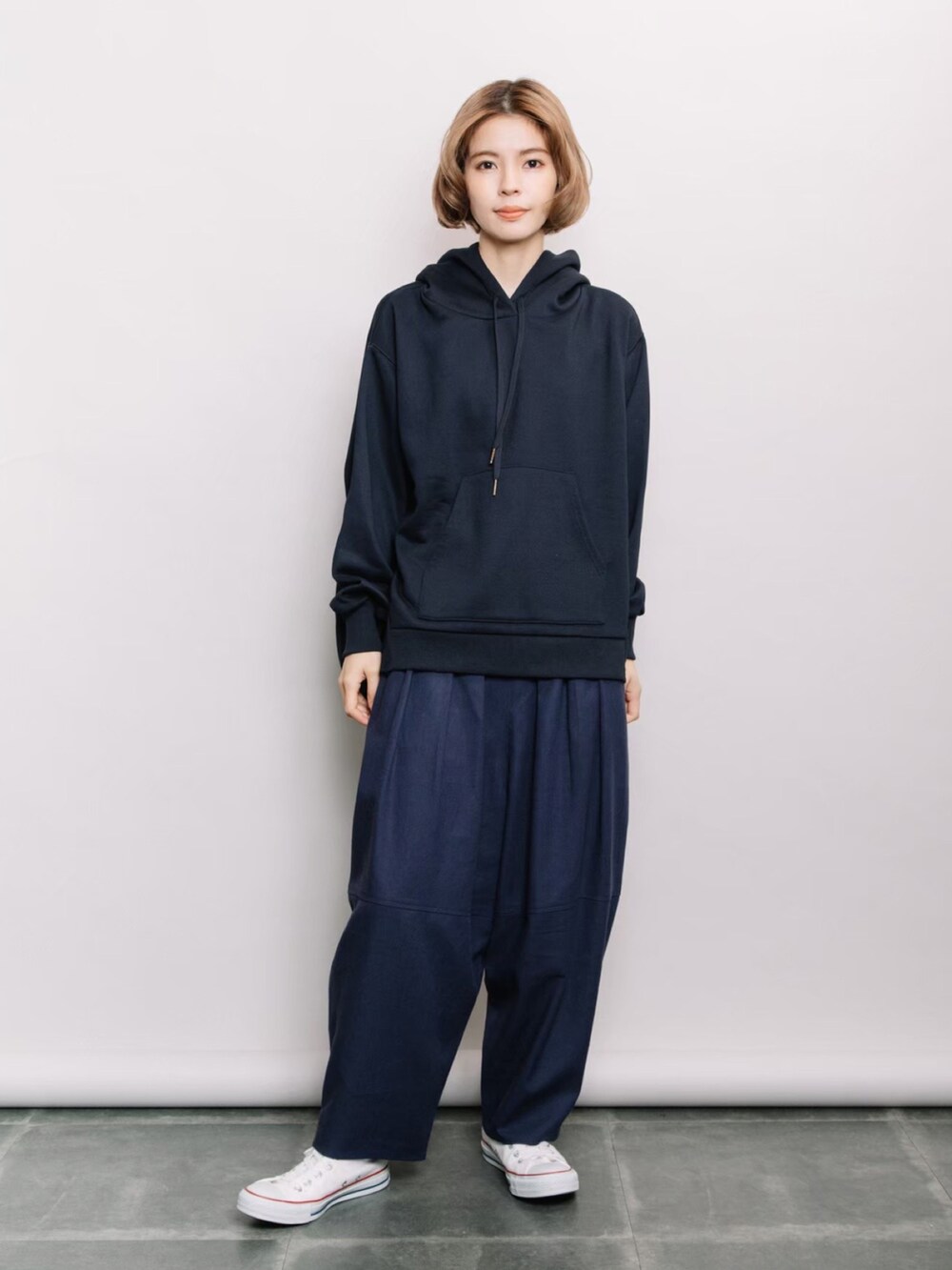 ブルー系のパーカー、ブルー系のデニムパンツ、ホワイト系のスニーカーを着用したレディースの冬コーディネートの2枚目の写真