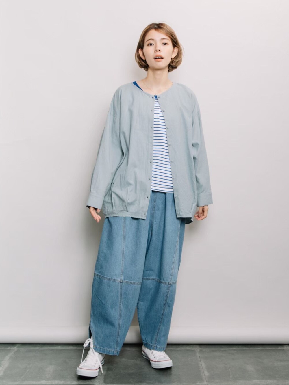 グリーン系のシャツ/ブラウス、ブルー系のタンクトップ、ブルー系のデニムパンツを着用したレディースの冬コーディネートの2枚目の写真