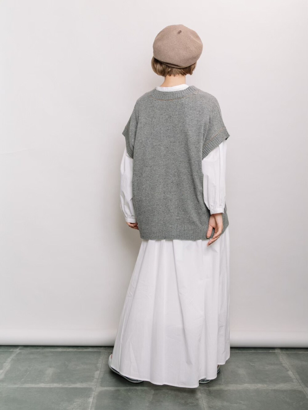 グレー系のベスト、ホワイト系のシャツ/ブラウス、ホワイト系のスカートを着用したレディースの冬コーディネートの3枚目の写真