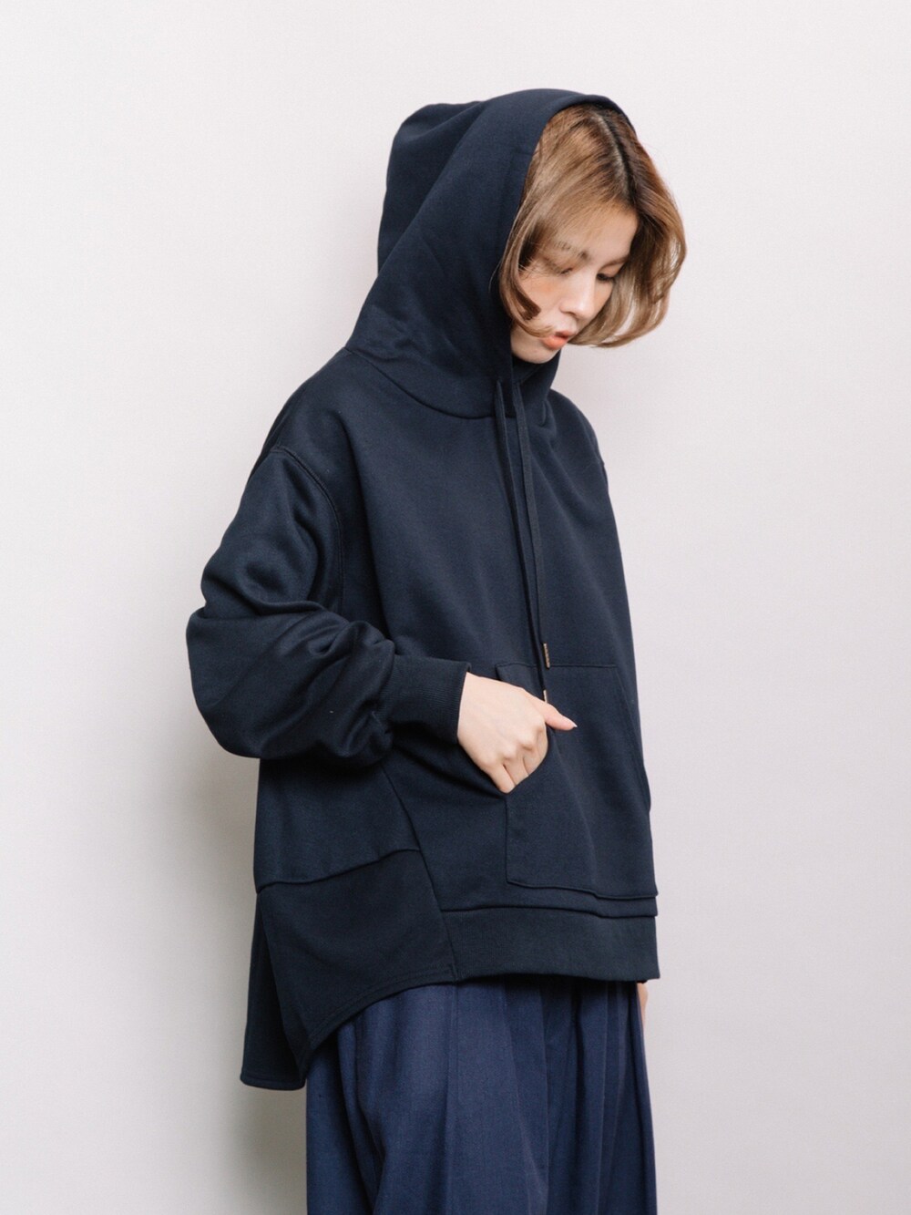 ブルー系のパーカー、ブルー系のデニムパンツ、ホワイト系のスニーカーを着用したレディースの冬コーディネートの4枚目の写真