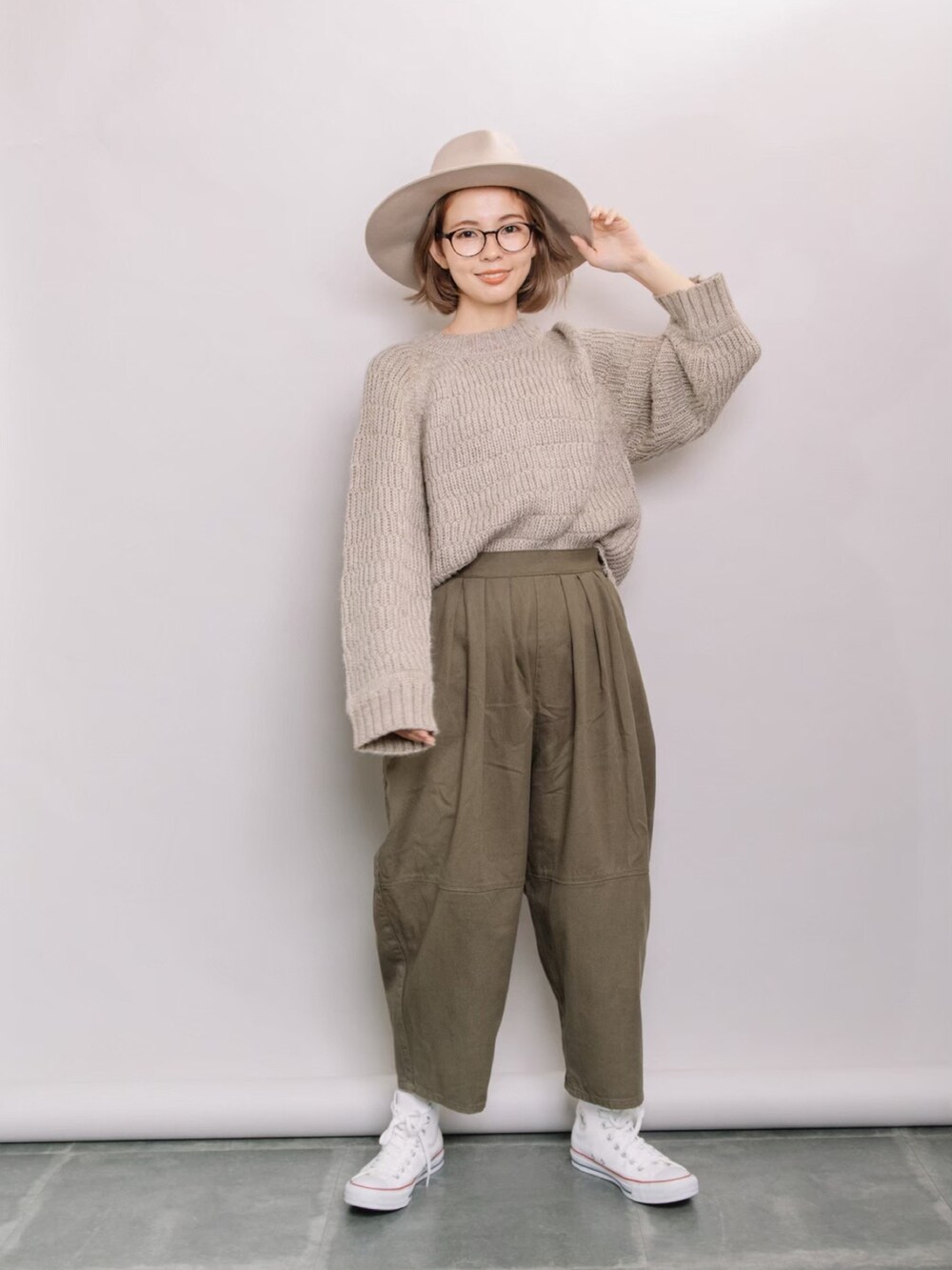 ベージュ系のニット/セーター、グリーン系のその他パンツ、ホワイト系のスニーカーを着用したレディースの秋コーディネートの3枚目の写真
