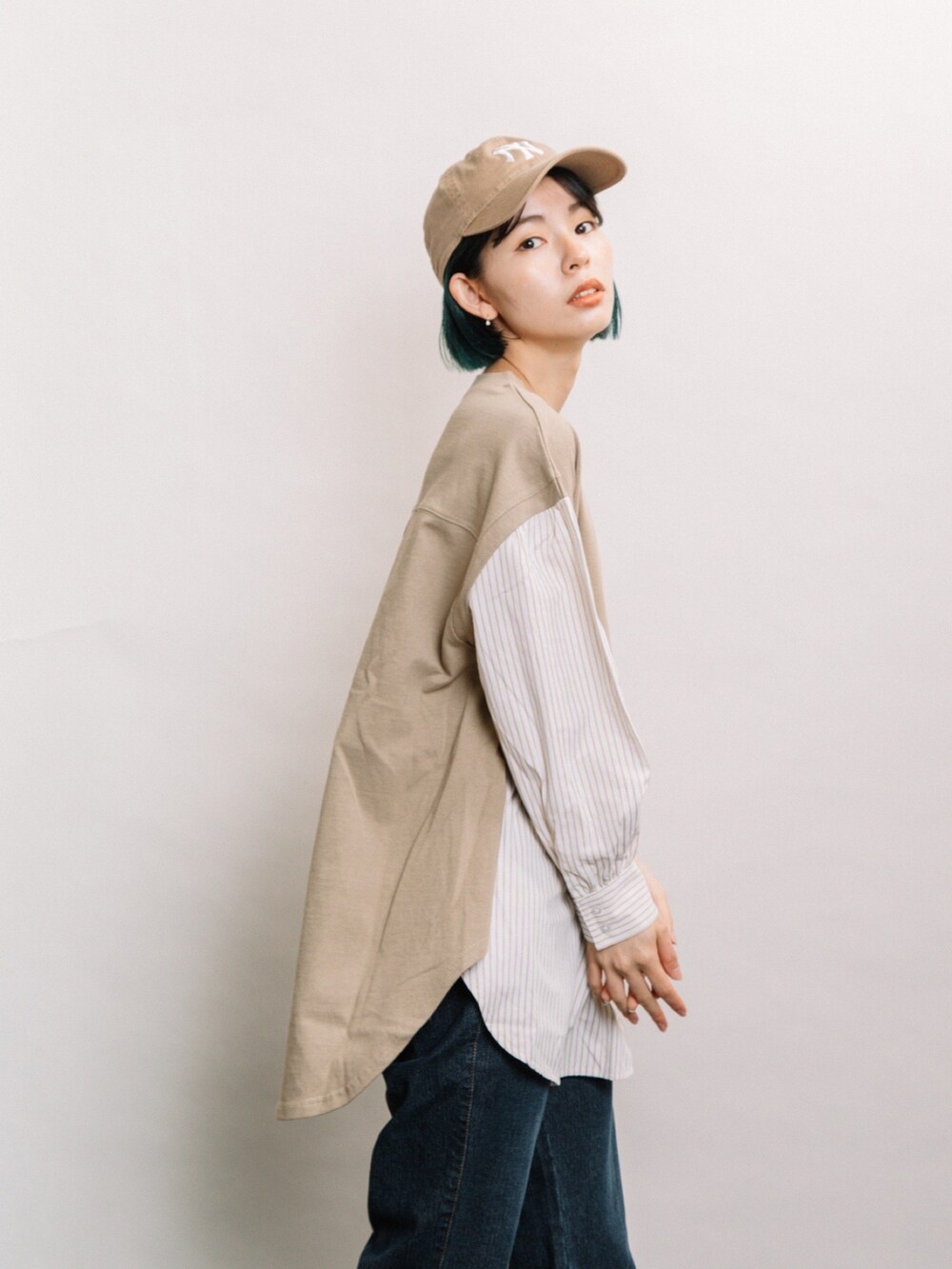 ブラウン系のTシャツ/カットソー、ブルー系のデニムパンツ、グレー系のスニーカーを着用したレディースの冬コーディネートの2枚目の写真