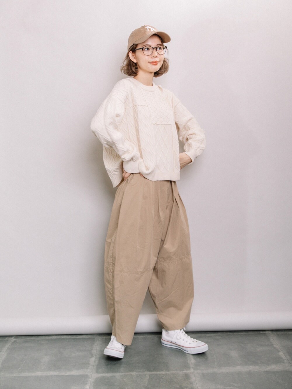 ホワイト系のニット/セーター、ベージュ系のその他パンツ、ホワイト系のスニーカーを着用したレディースの春コーディネートの2枚目の写真
