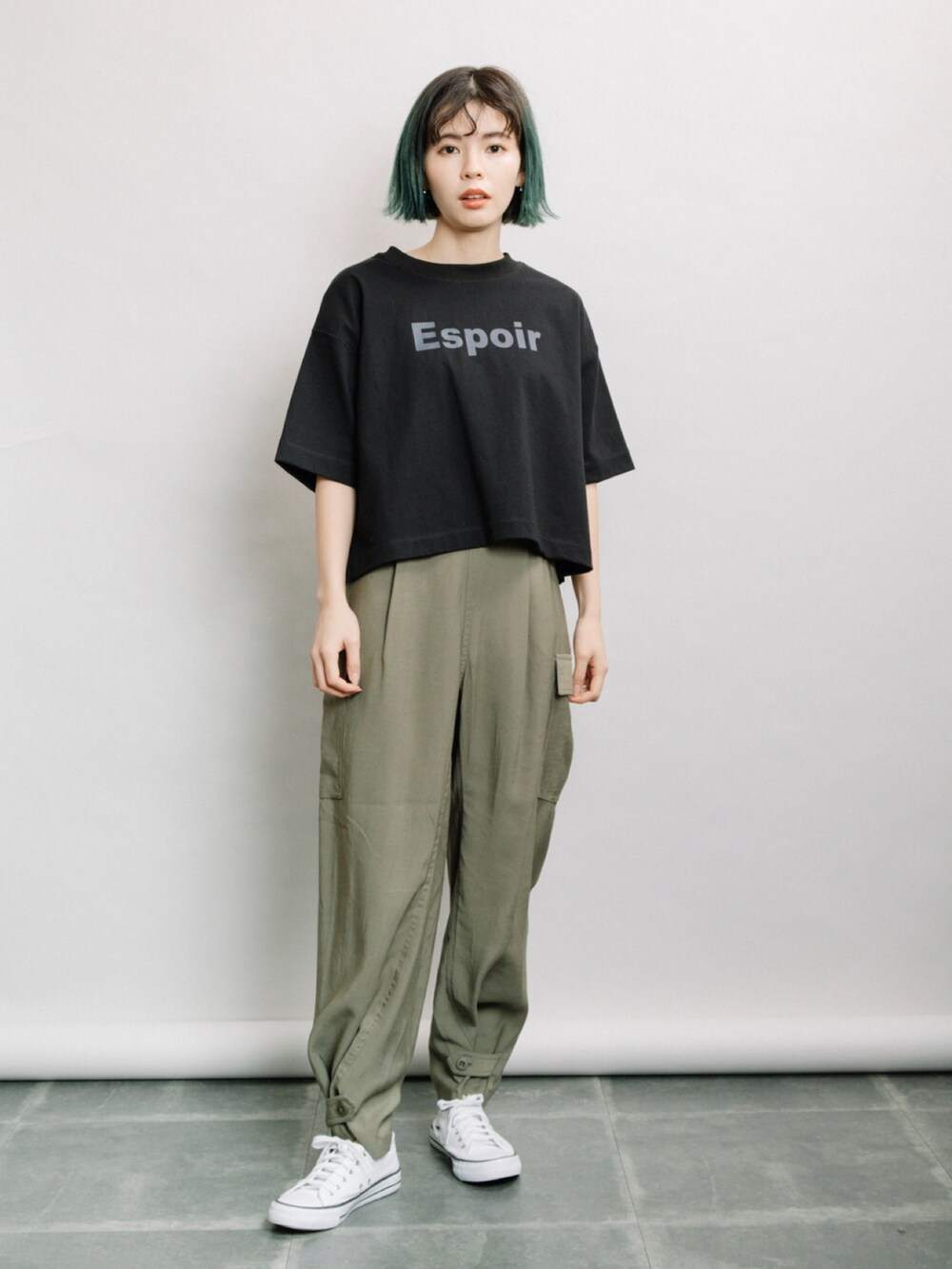 ブラック系のTシャツ/カットソー、グリーン系のその他パンツ、ホワイト系のスニーカーを着用したレディースの春コーディネートの2枚目の写真