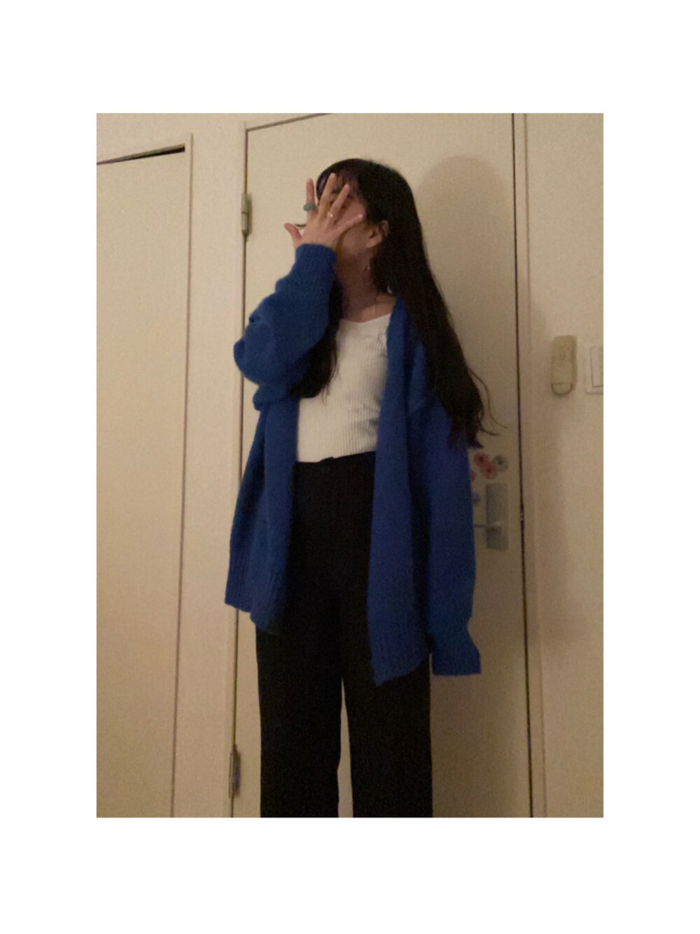 ブラック系のパンツ、ブルー系のカーディガン/ボレロ、ホワイト系のTシャツ/カットソーを着用したレディースの冬コーディネートの2枚目の写真