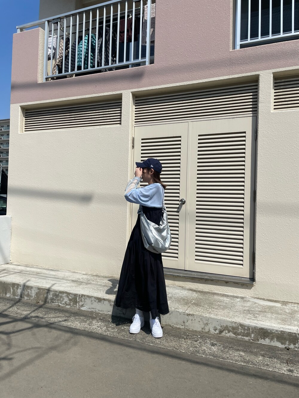 ブラック系のワンピース、シルバー系のショルダーバッグ、ブルー系のTシャツ/カットソーを着用したレディースの春コーディネートの2枚目の写真