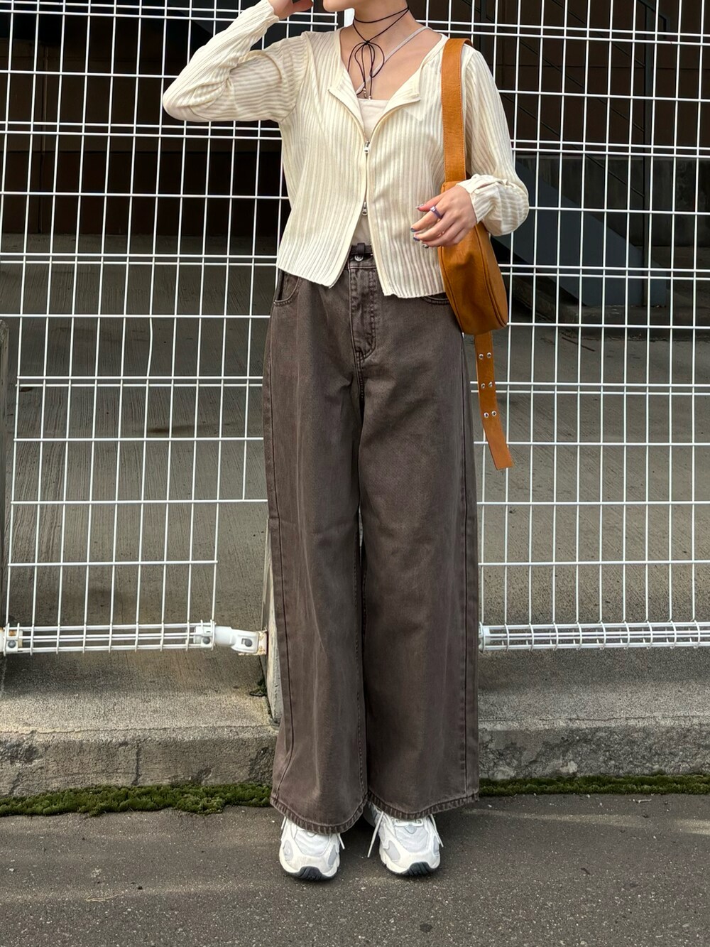 ブラック系のトップスを着用したレディースの秋コーディネートの2枚目の写真