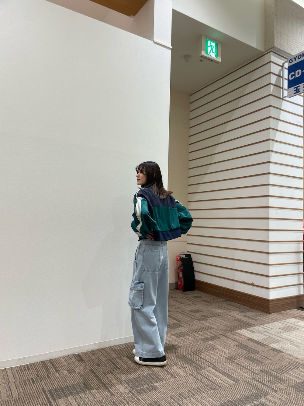 ブルー系のカーゴパンツ、グリーン系のナイロンジャケットを着用したレディースの春コーディネートの2枚目の写真