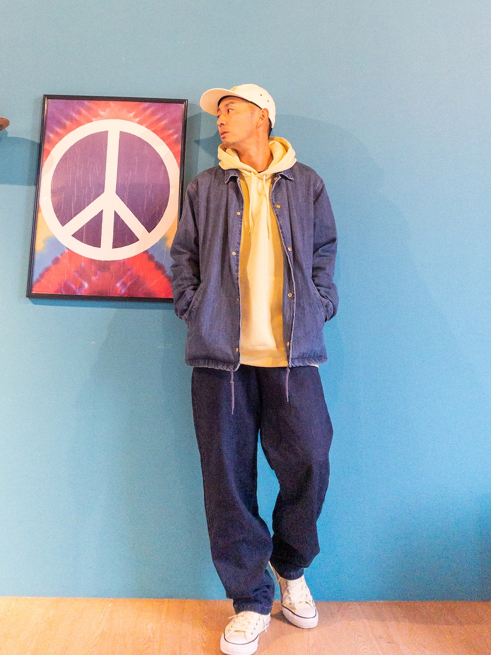 ブルー系のデニムジャケット、イエロー系のパーカー、ブルー系のその他パンツを着用したメンズの春コーディネートの3枚目の写真