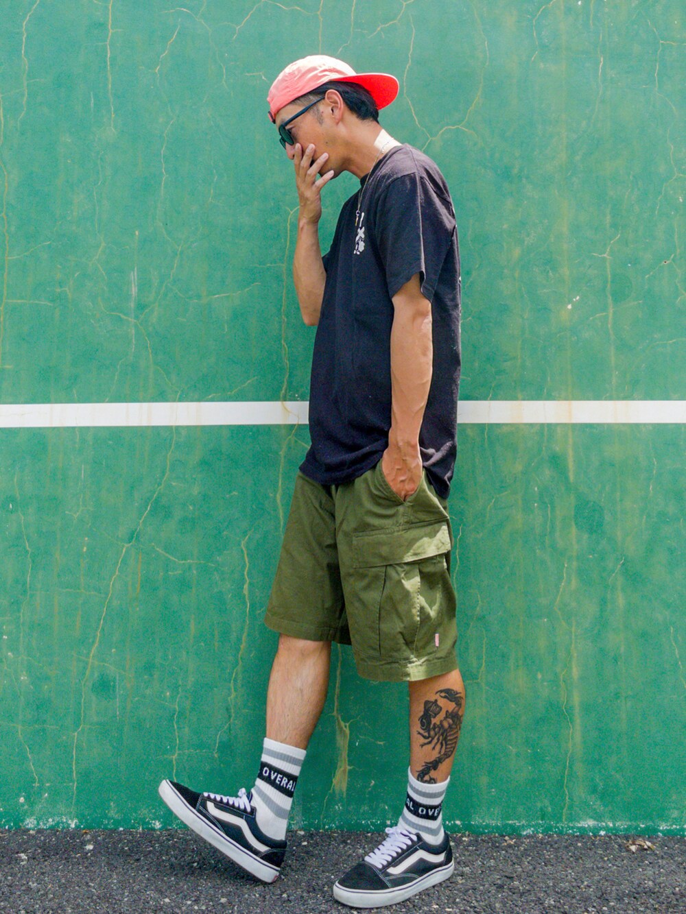 ブラック系のTシャツ/カットソー、グリーン系のその他パンツ、ブラック系のスニーカーを着用したメンズの夏コーディネートの2枚目の写真