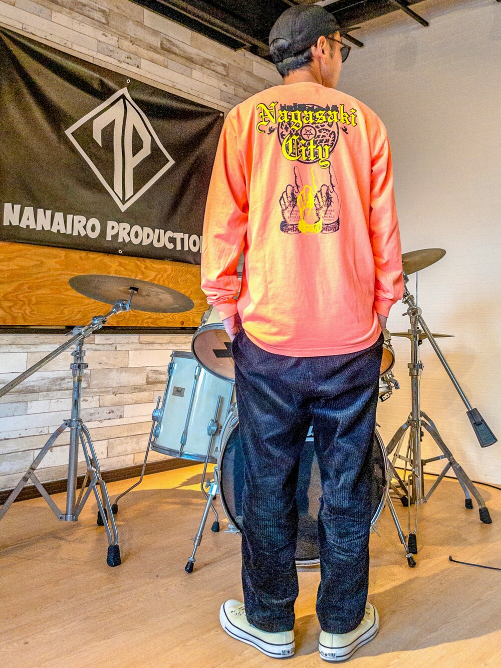 オレンジ系のTシャツ/カットソー、オレンジ系のTシャツ/カットソー、ブラック系のその他パンツを着用したメンズの春コーディネートの2枚目の写真