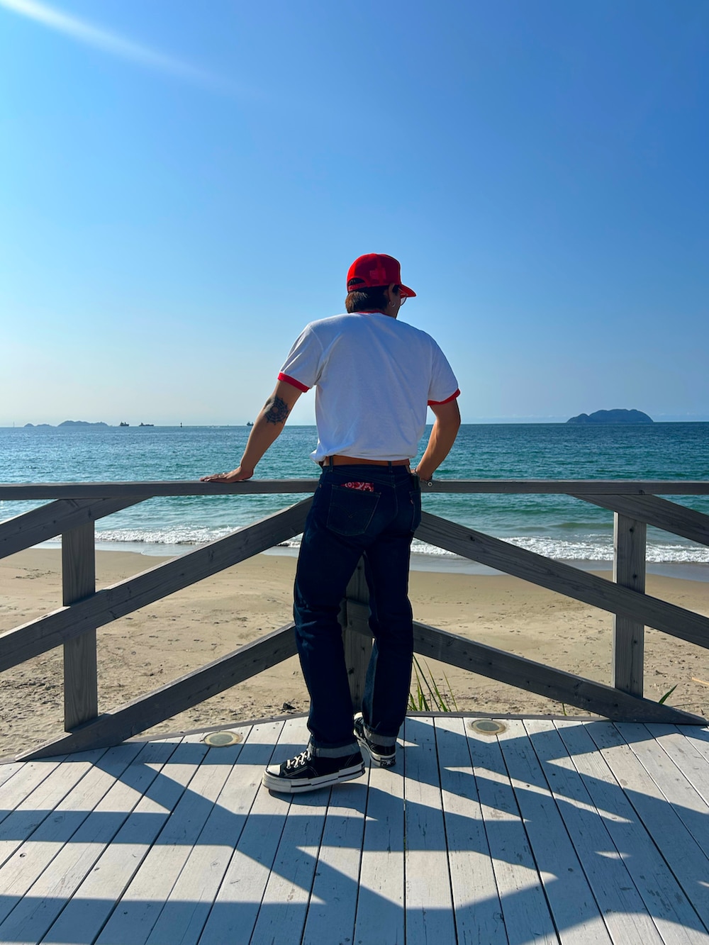 ブルー系のデニムパンツ、ブラック系のスニーカーを着用したメンズの秋コーディネートの2枚目の写真