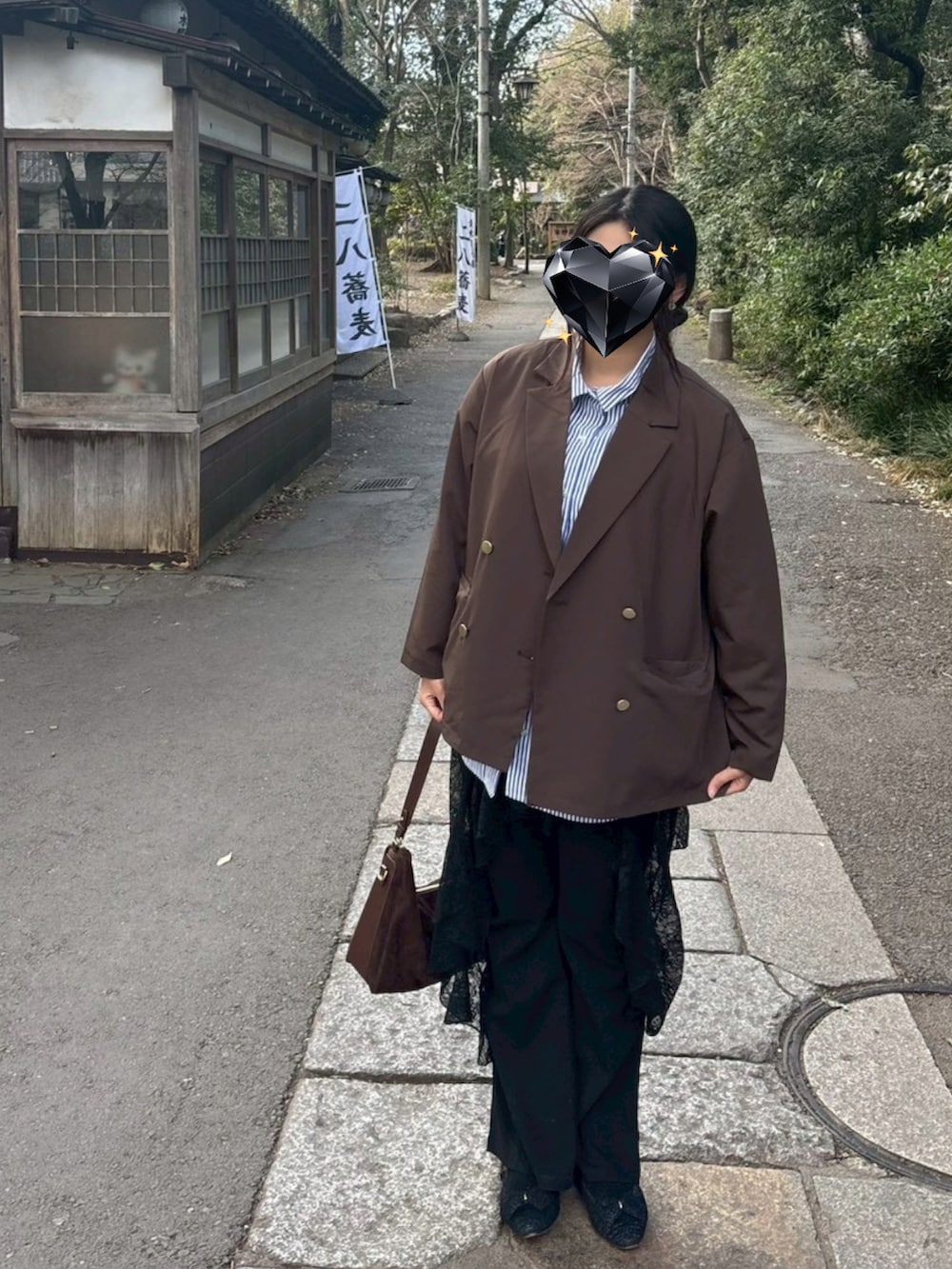 ブラウン系のテーラードジャケット、ブラウン系のボストンバッグを着用したレディースの冬コーディネートの2枚目の写真