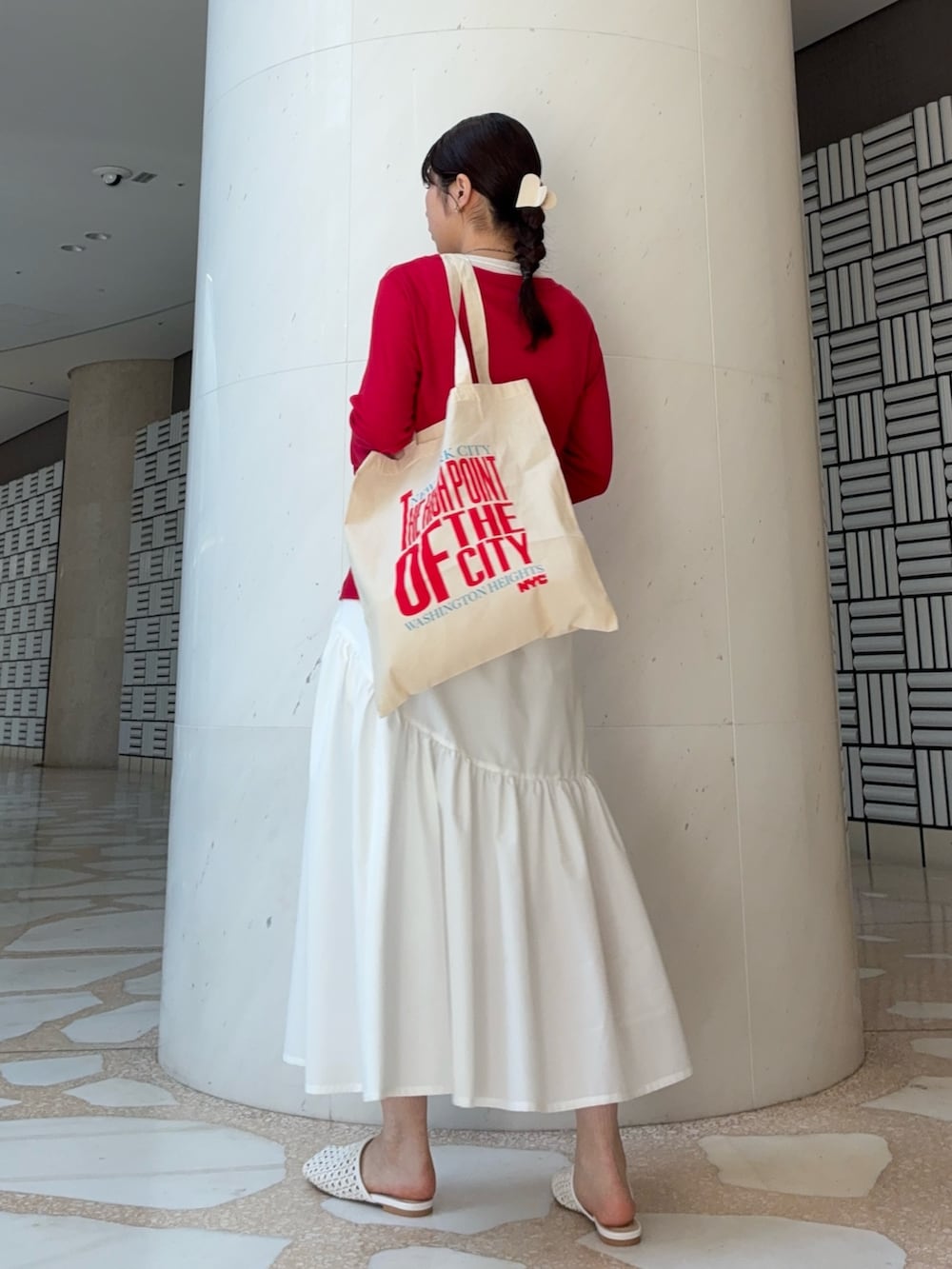 レッド系のTシャツ/カットソー、ホワイト系のスカート、ホワイト系のサンダルを着用したレディースの春コーディネートの2枚目の写真