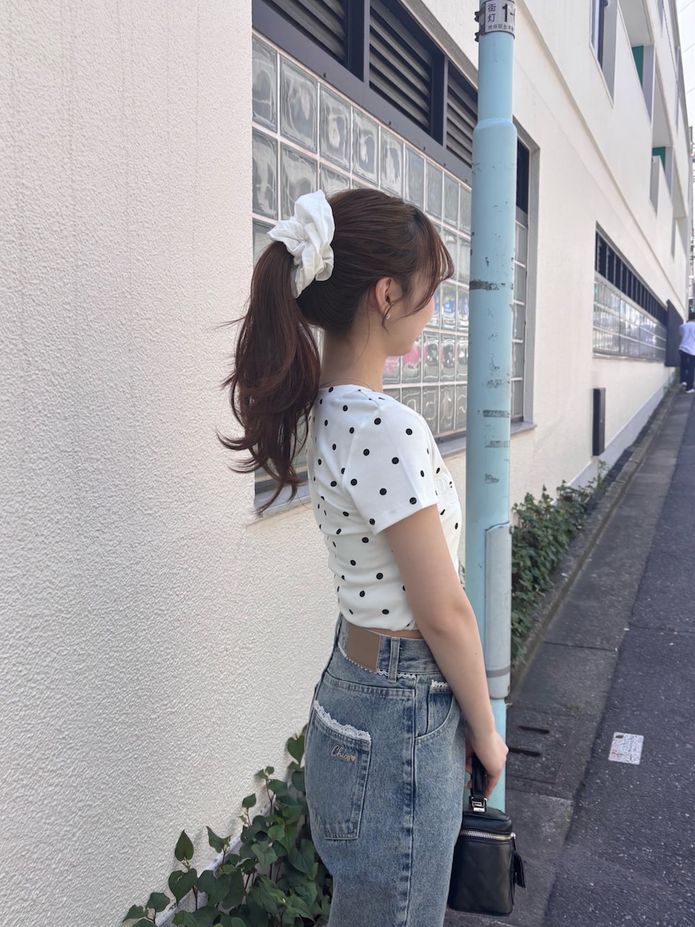 ホワイト系のTシャツ/カットソー、ブルー系のデニムパンツ、ブラック系のショルダーバッグを着用したレディースの春コーディネートの3枚目の写真
