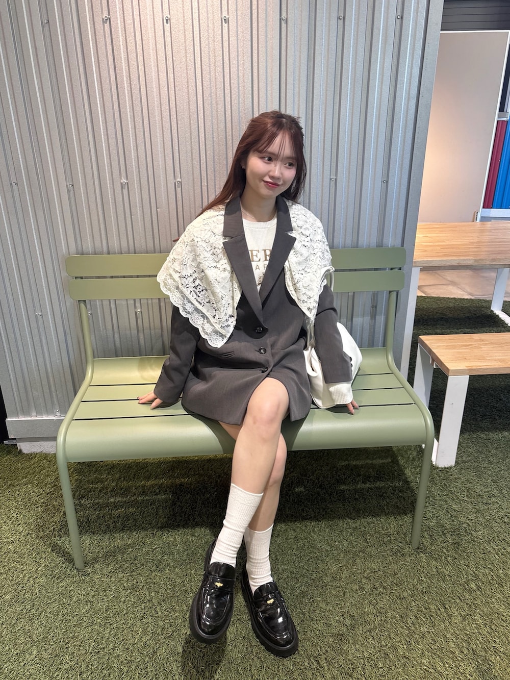 グレー系のテーラードジャケット、ホワイト系のボストンバッグ、ホワイト系のニット/セーターを着用したレディースの冬コーディネートの4枚目の写真