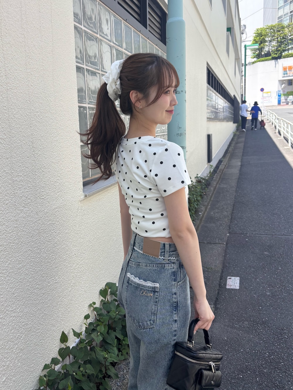 ホワイト系のTシャツ/カットソー、ブルー系のデニムパンツ、ブラック系のショルダーバッグを着用したレディースの春コーディネートの2枚目の写真