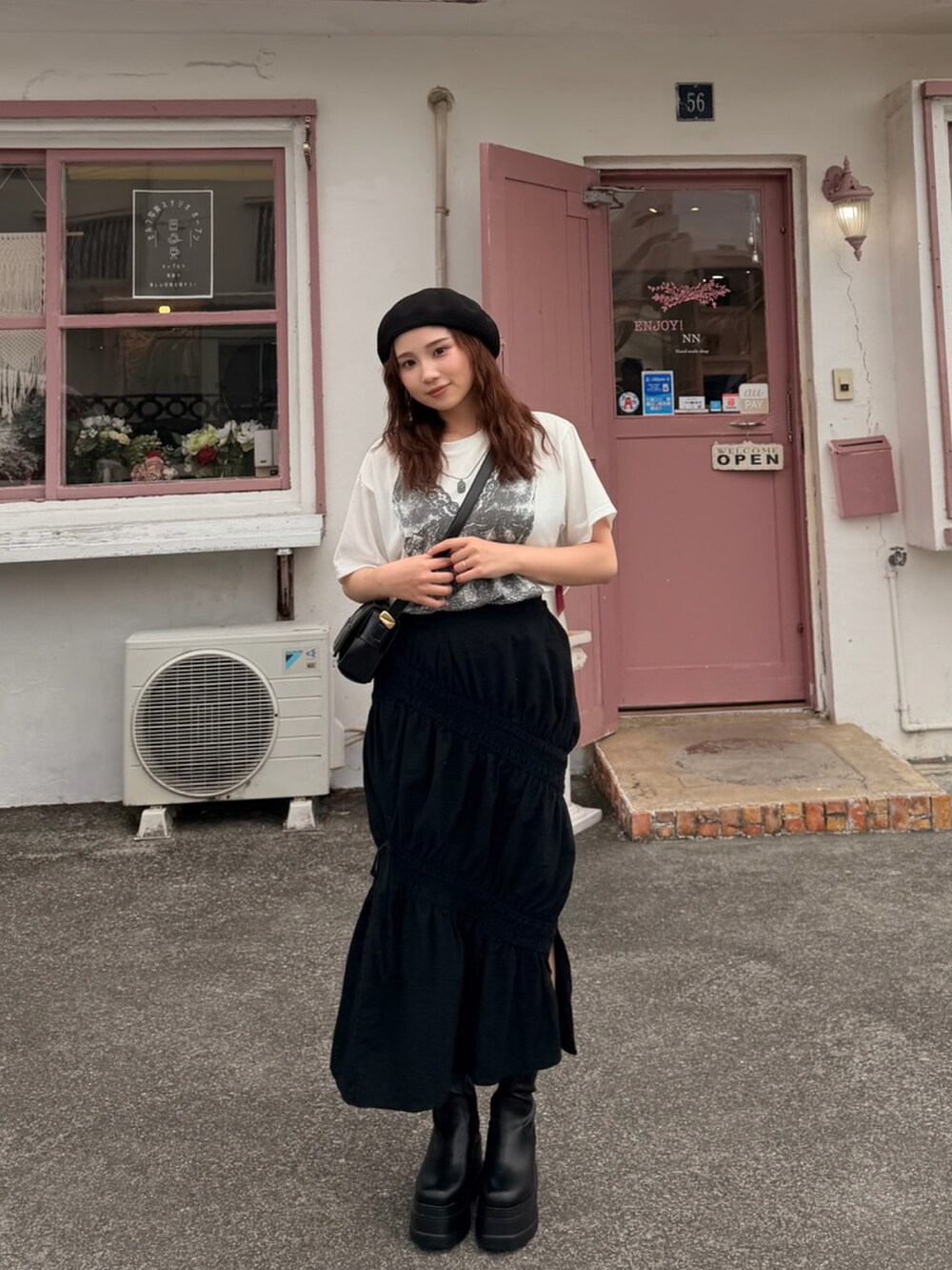 ホワイト系のTシャツ/カットソー、ブラック系のスカート、ブラック系のブーツを着用したレディースの春コーディネートの2枚目の写真