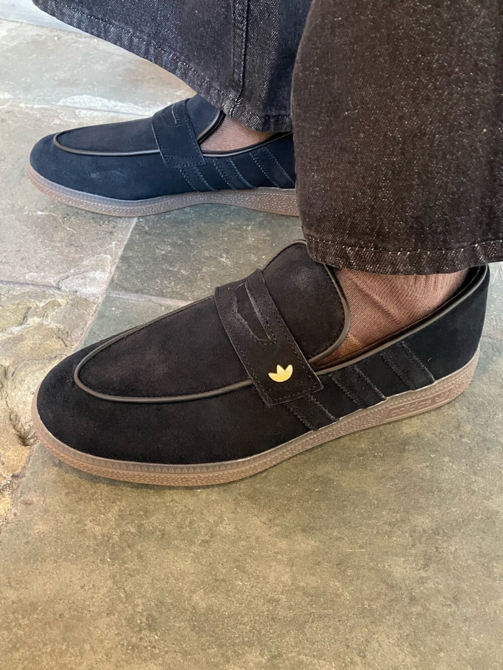 ブラック系のデニムパンツ、ブラック系のスニーカー、ブラック系のパーカーを着用したメンズの冬コーディネートの4枚目の写真