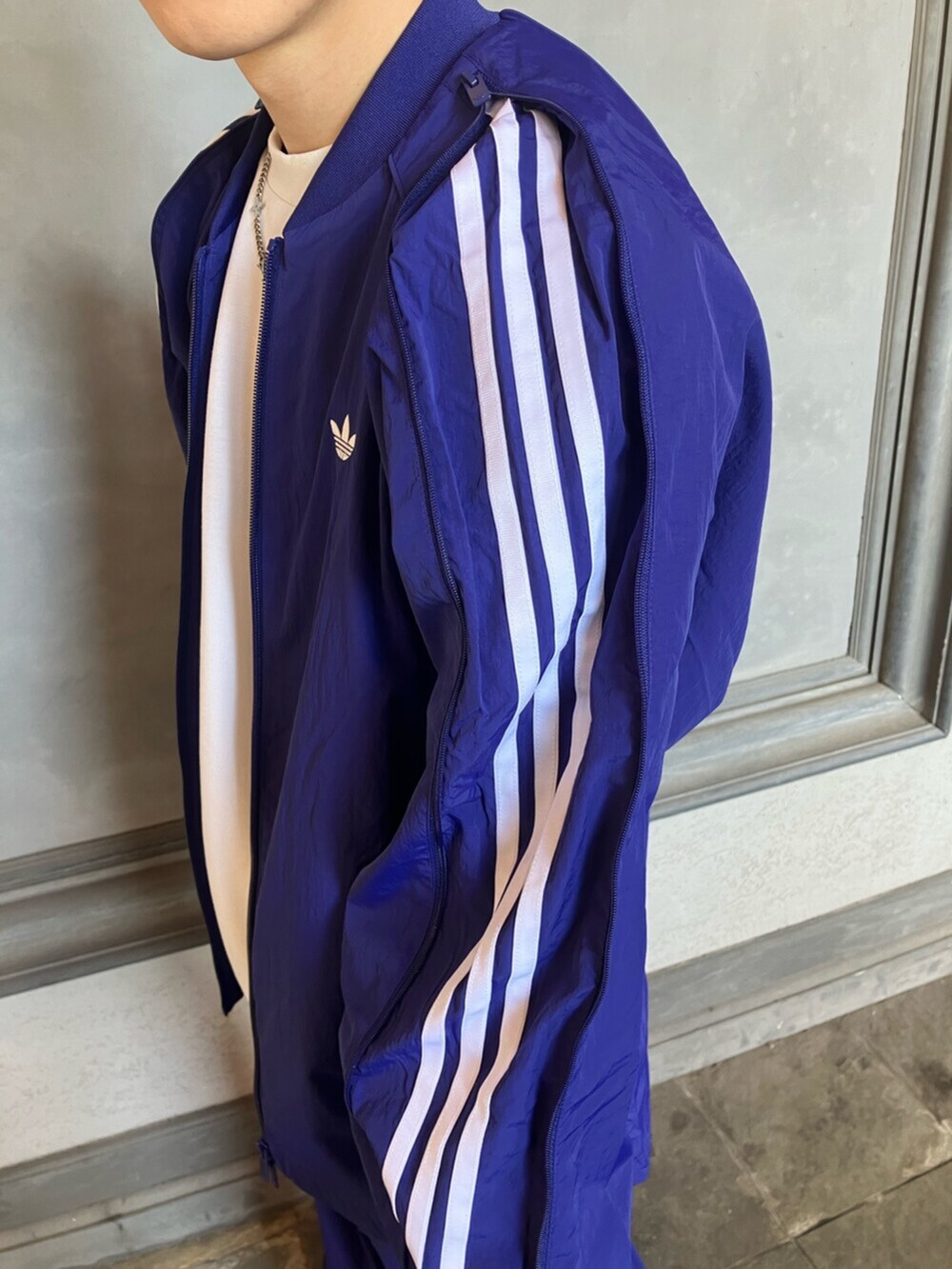 ホワイト系のシューズ、ブルー系のジャージ、ブルー系のスウェットパンツを着用したメンズの春コーディネートの3枚目の写真