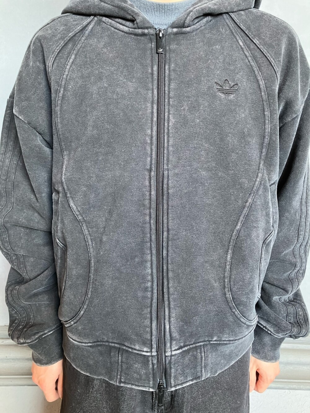 ブラック系のデニムパンツ、ブラック系のスニーカー、ブラック系のパーカーを着用したメンズの冬コーディネートの3枚目の写真