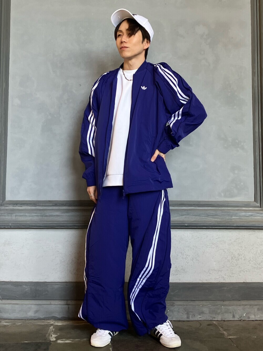 ホワイト系のシューズ、ブルー系のジャージ、ブルー系のスウェットパンツを着用したメンズの春コーディネートの2枚目の写真