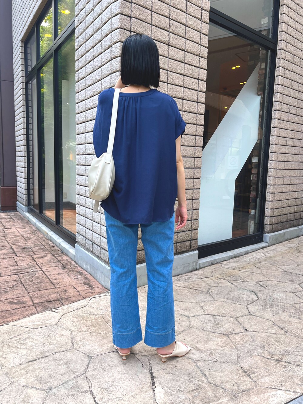 ブルー系のシャツ/ブラウス、ブルー系のデニムパンツ、ホワイト系のサンダルを着用したレディースの夏コーディネートの2枚目の写真