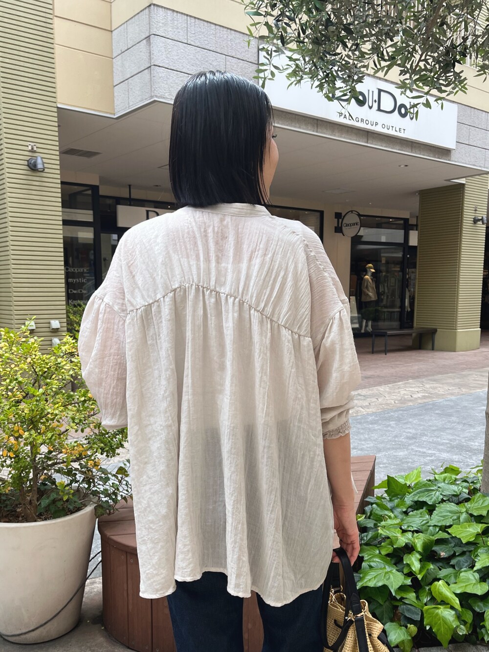 ベージュ系のシャツ/ブラウス、ホワイト系のキャミソール、ブルー系のデニムパンツを着用したレディースの春コーディネートの3枚目の写真