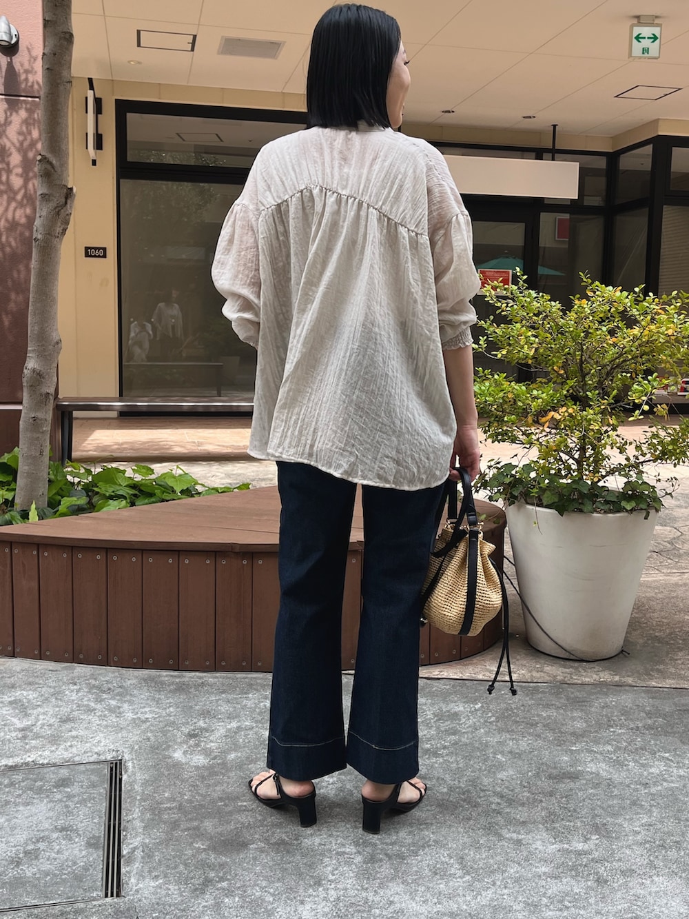 ベージュ系のシャツ/ブラウス、ホワイト系のキャミソール、ブルー系のデニムパンツを着用したレディースの春コーディネートの2枚目の写真