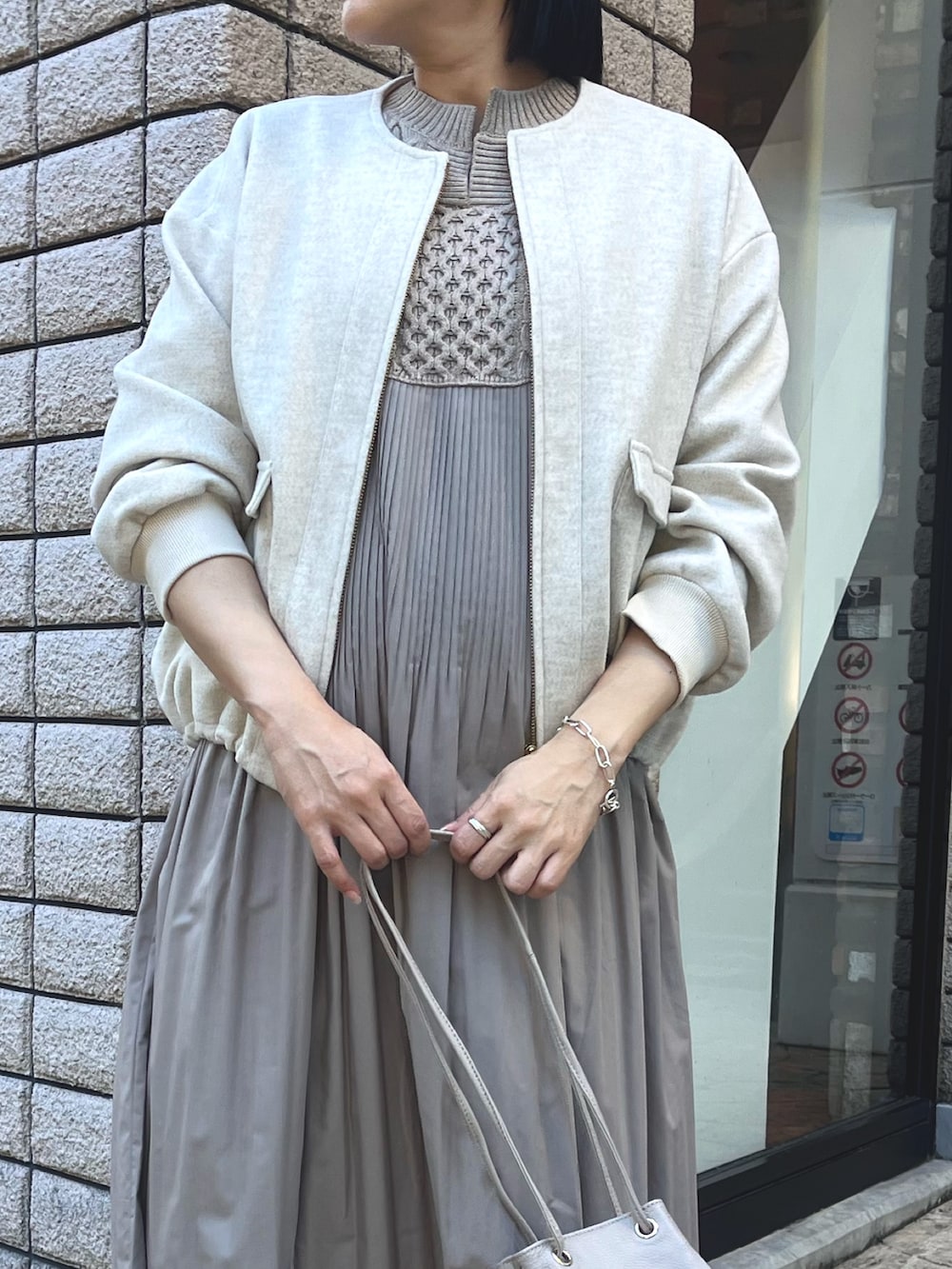 ベージュ系のブルゾン、ベージュ系のワンピース、グレー系のトートバッグを着用したレディースの秋コーディネートの3枚目の写真