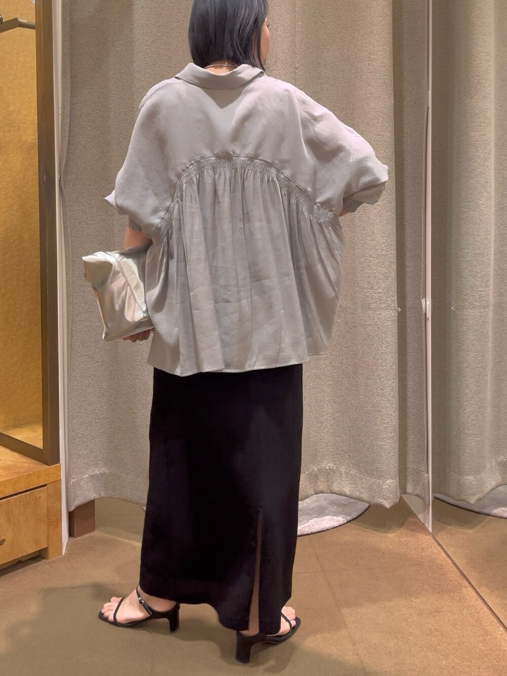 ブラック系のスカート、グレー系のシャツ/ブラウス、ホワイト系のキャミソールを着用したレディースの春コーディネートの2枚目の写真