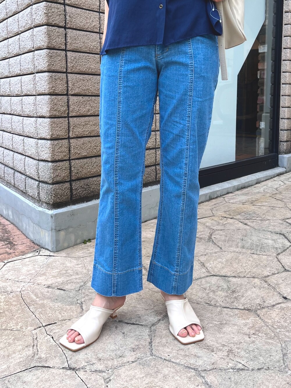 ブルー系のシャツ/ブラウス、ブルー系のデニムパンツ、ホワイト系のサンダルを着用したレディースの夏コーディネートの3枚目の写真