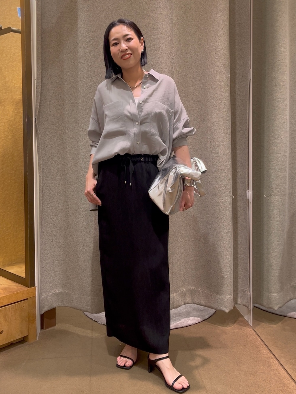 ブラック系のスカート、グレー系のシャツ/ブラウス、ホワイト系のキャミソールを着用したレディースの春コーディネートの3枚目の写真