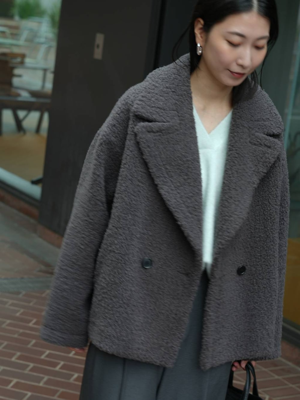 グレー系のその他パンツ、ブラック系のローファー、ブルー系のニット/セーターを着用したレディースの秋コーディネートの5枚目の写真