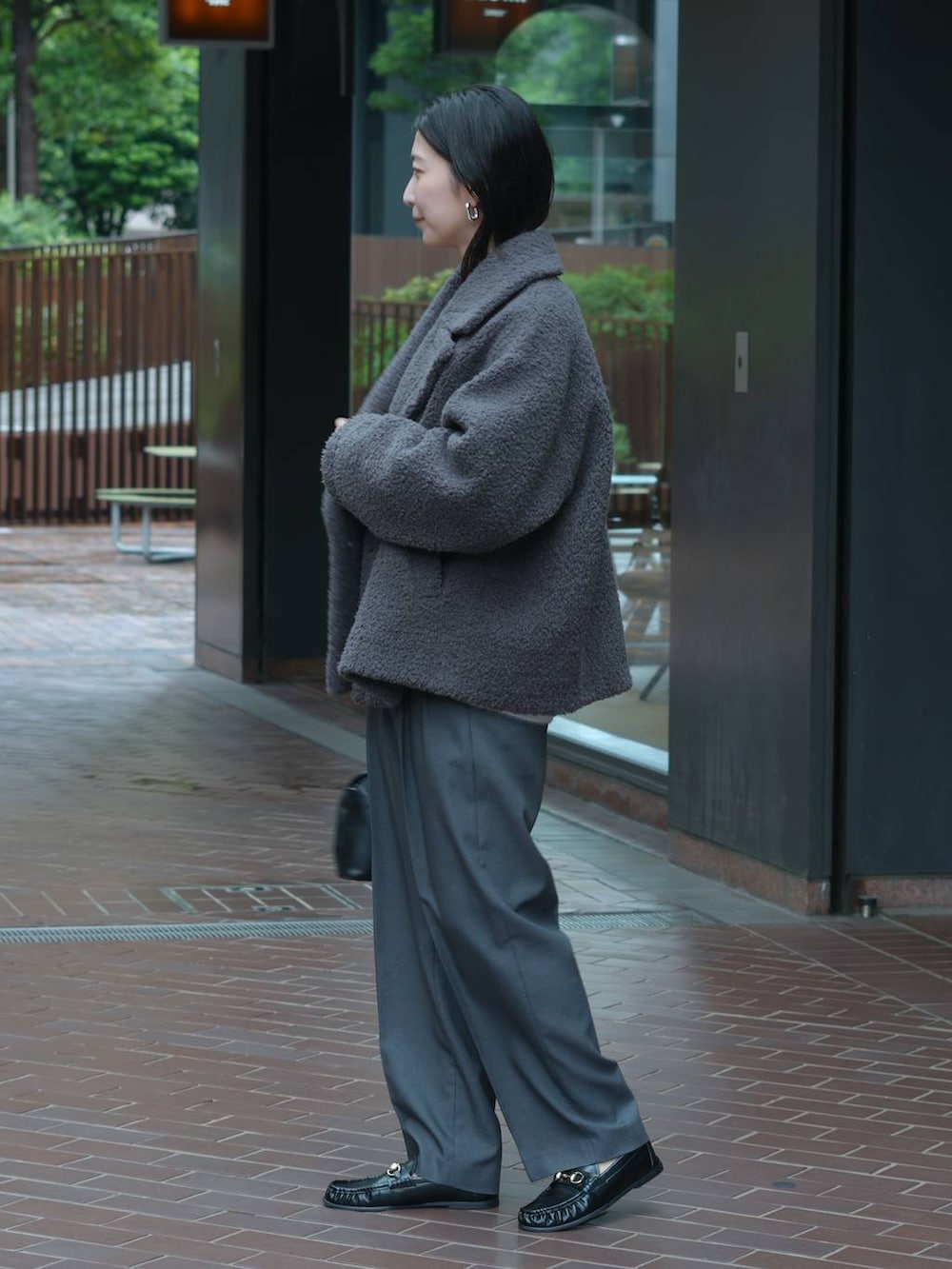 グレー系のその他パンツ、ブラック系のローファー、ブルー系のニット/セーターを着用したレディースの秋コーディネートの6枚目の写真
