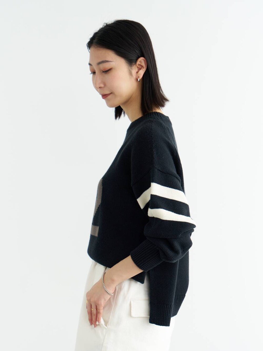 ホワイト系のパンプス、ブルー系のニット/セーター、ホワイト系のシャツ/ブラウスを着用したレディースの冬コーディネートの6枚目の写真