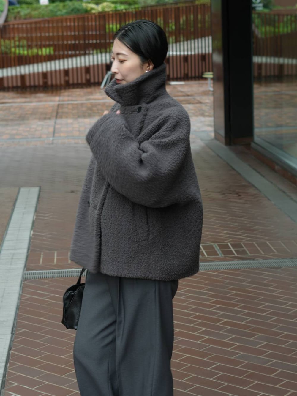 グレー系のその他パンツ、ブラック系のローファー、ブルー系のニット/セーターを着用したレディースの秋コーディネートの2枚目の写真