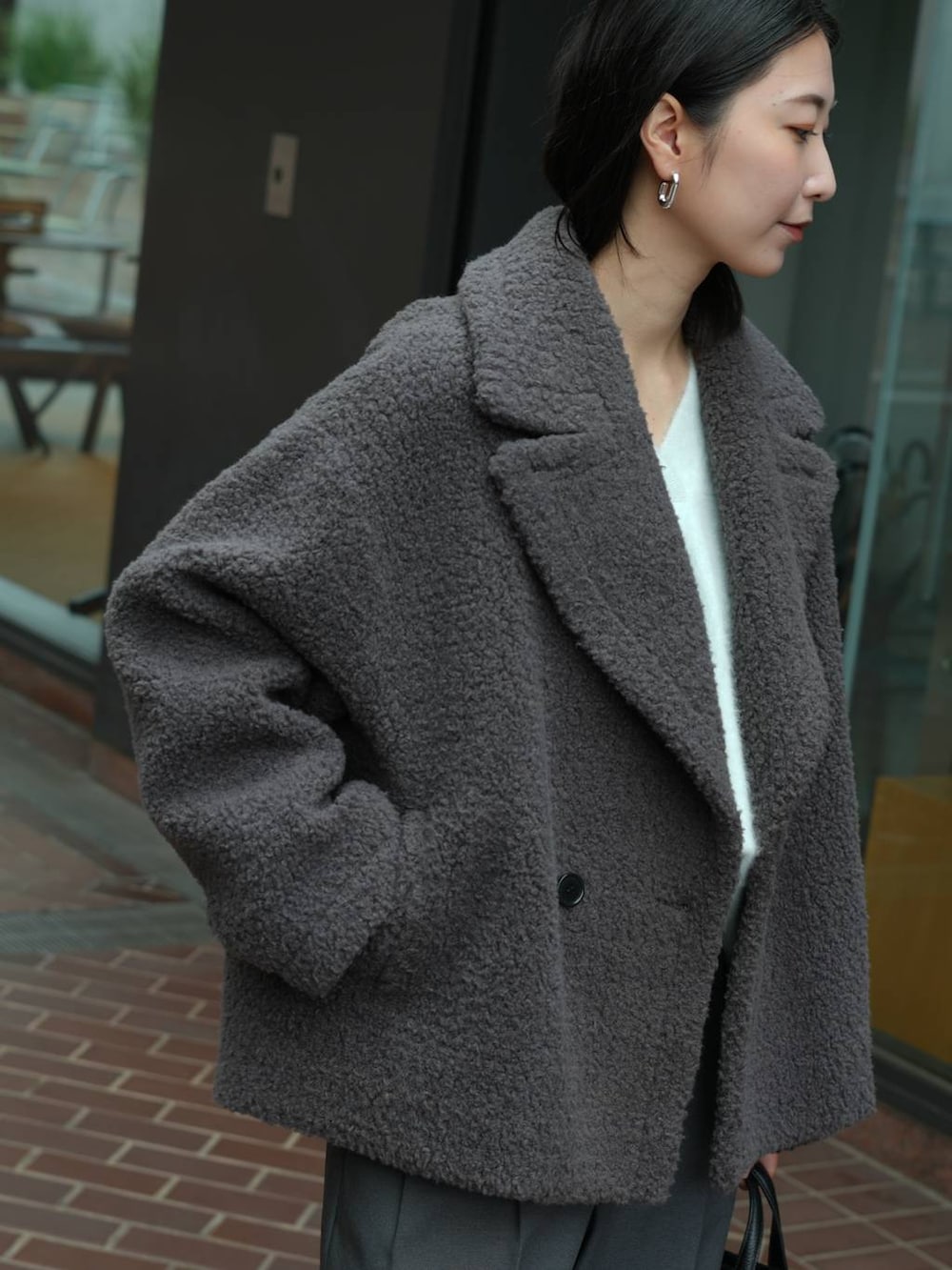 グレー系のその他パンツ、ブラック系のローファー、ブルー系のニット/セーターを着用したレディースの秋コーディネートの4枚目の写真