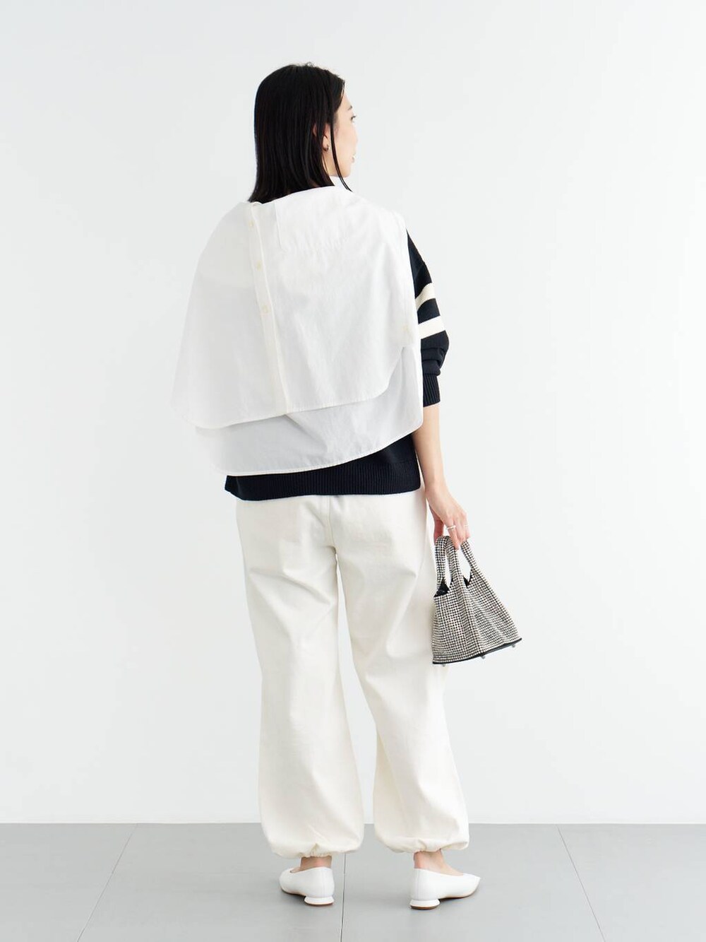 ホワイト系のパンプス、ブルー系のニット/セーター、ホワイト系のシャツ/ブラウスを着用したレディースの冬コーディネートの4枚目の写真