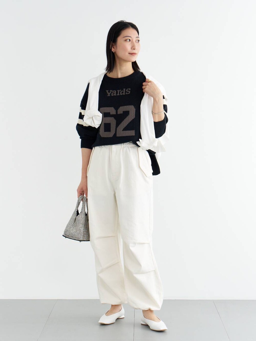 ホワイト系のパンプス、ブルー系のニット/セーター、ホワイト系のシャツ/ブラウスを着用したレディースの冬コーディネートの2枚目の写真