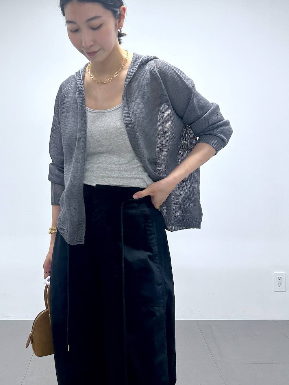 ブラック系のサンダル、ブラック系のカーゴパンツ、グレー系のカーディガン/ボレロを着用したレディースの夏コーディネートの2枚目の写真