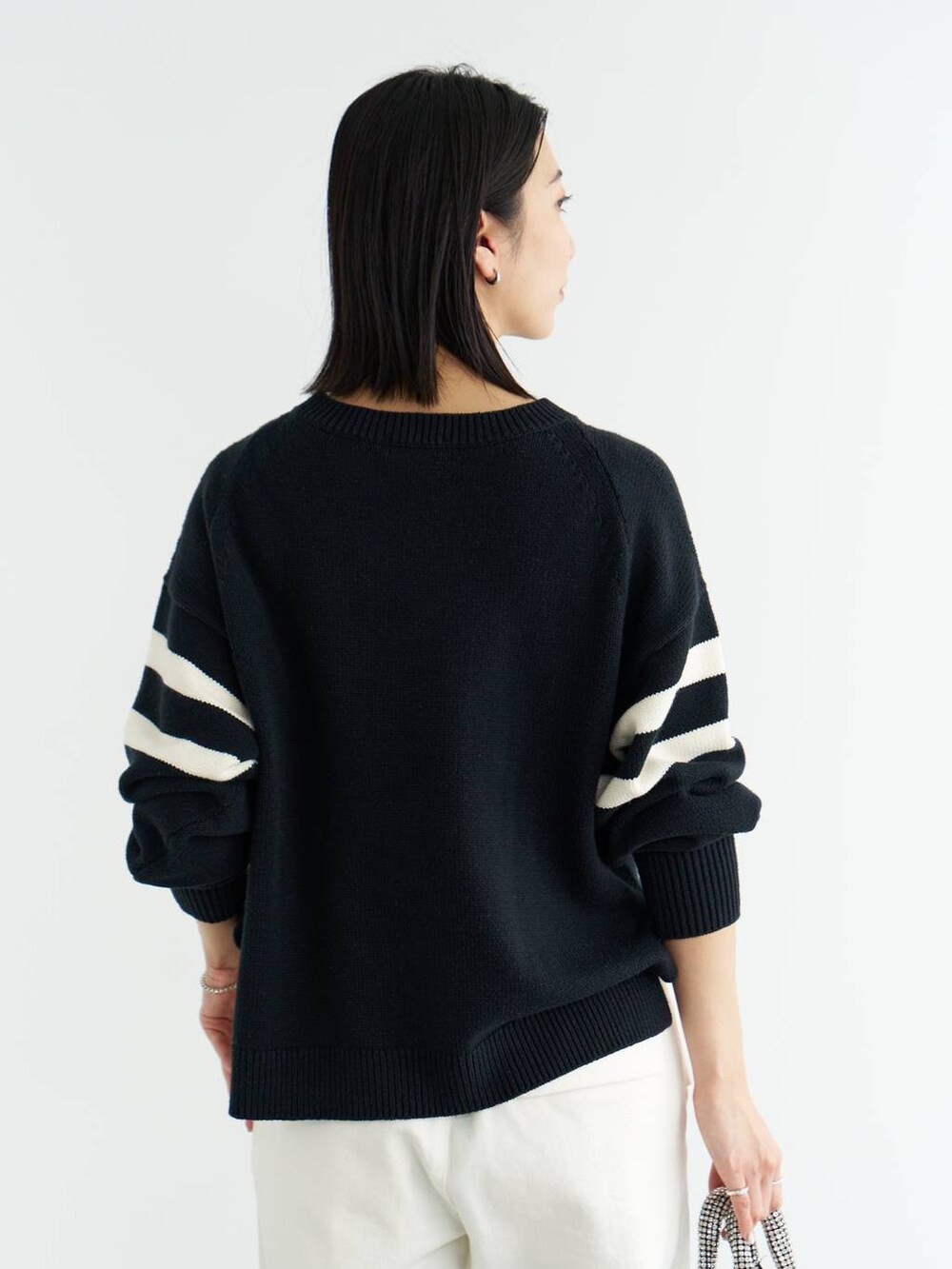 ホワイト系のパンプス、ブルー系のニット/セーター、ホワイト系のシャツ/ブラウスを着用したレディースの冬コーディネートの7枚目の写真