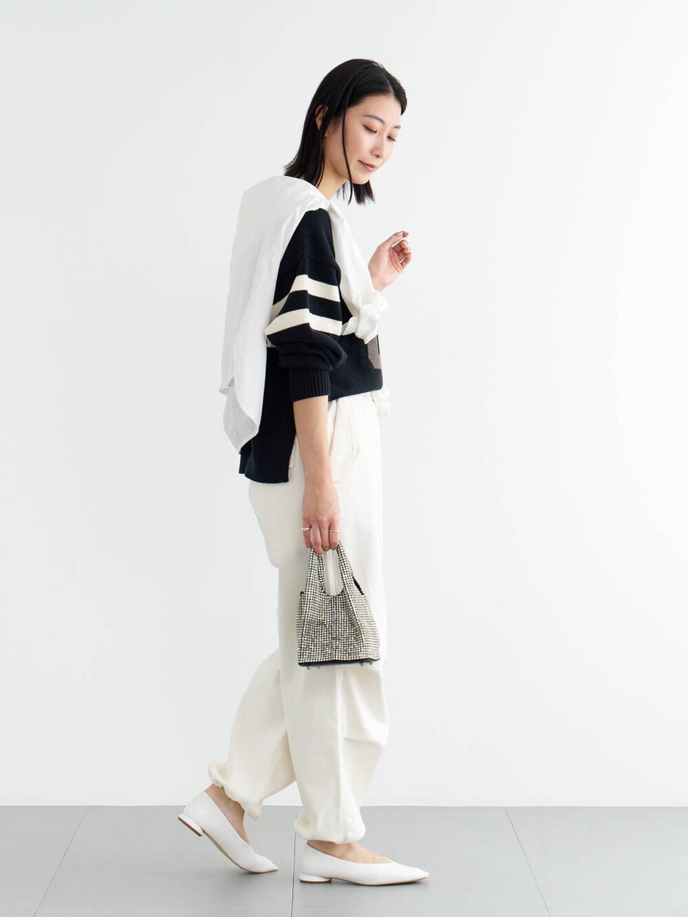 ホワイト系のパンプス、ブルー系のニット/セーター、ホワイト系のシャツ/ブラウスを着用したレディースの冬コーディネートの3枚目の写真