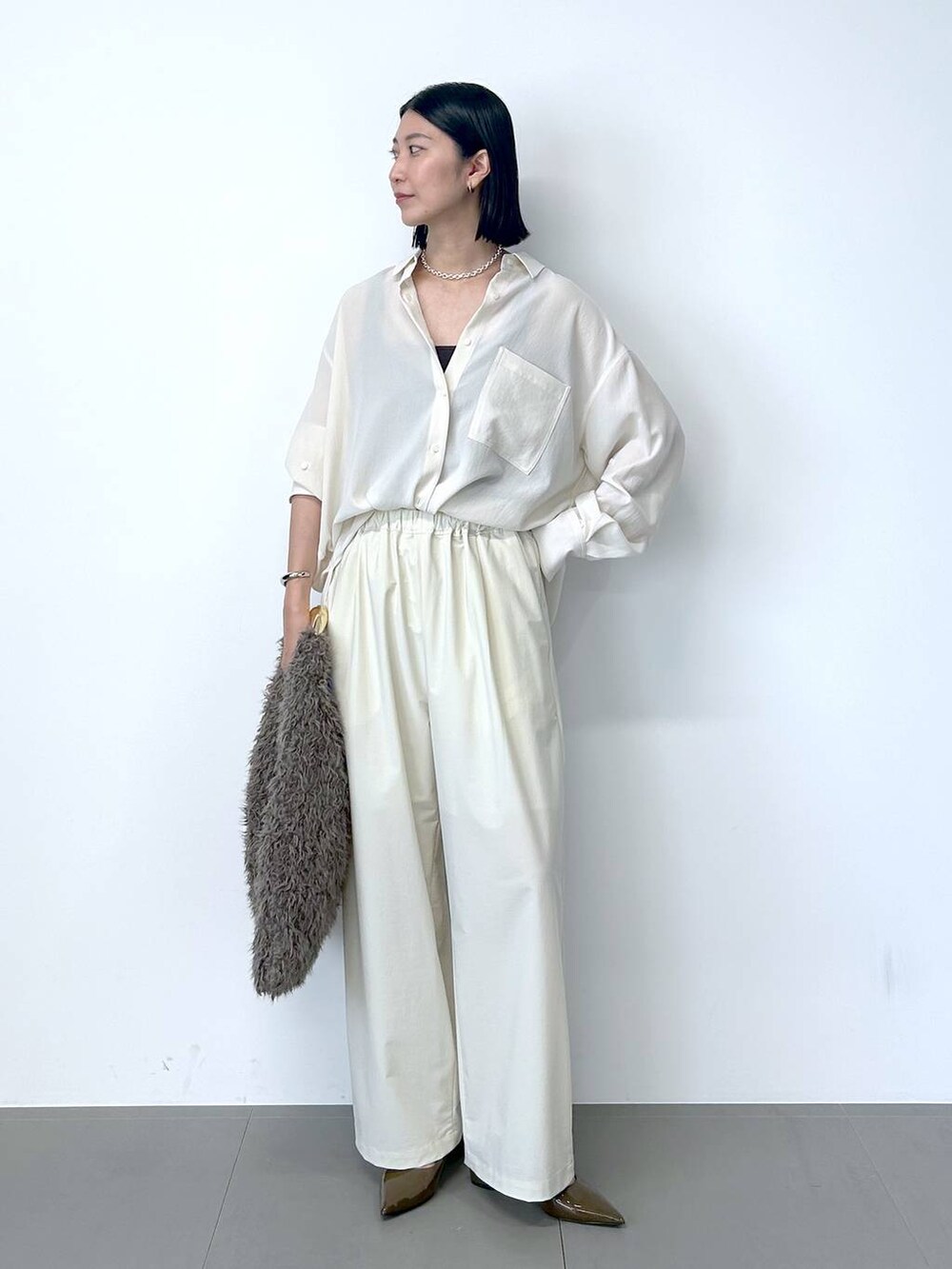 ブラウン系のパンプス、ホワイト系のその他パンツ、ベージュ系のシャツ/ブラウスを着用したレディースの夏コーディネートの3枚目の写真