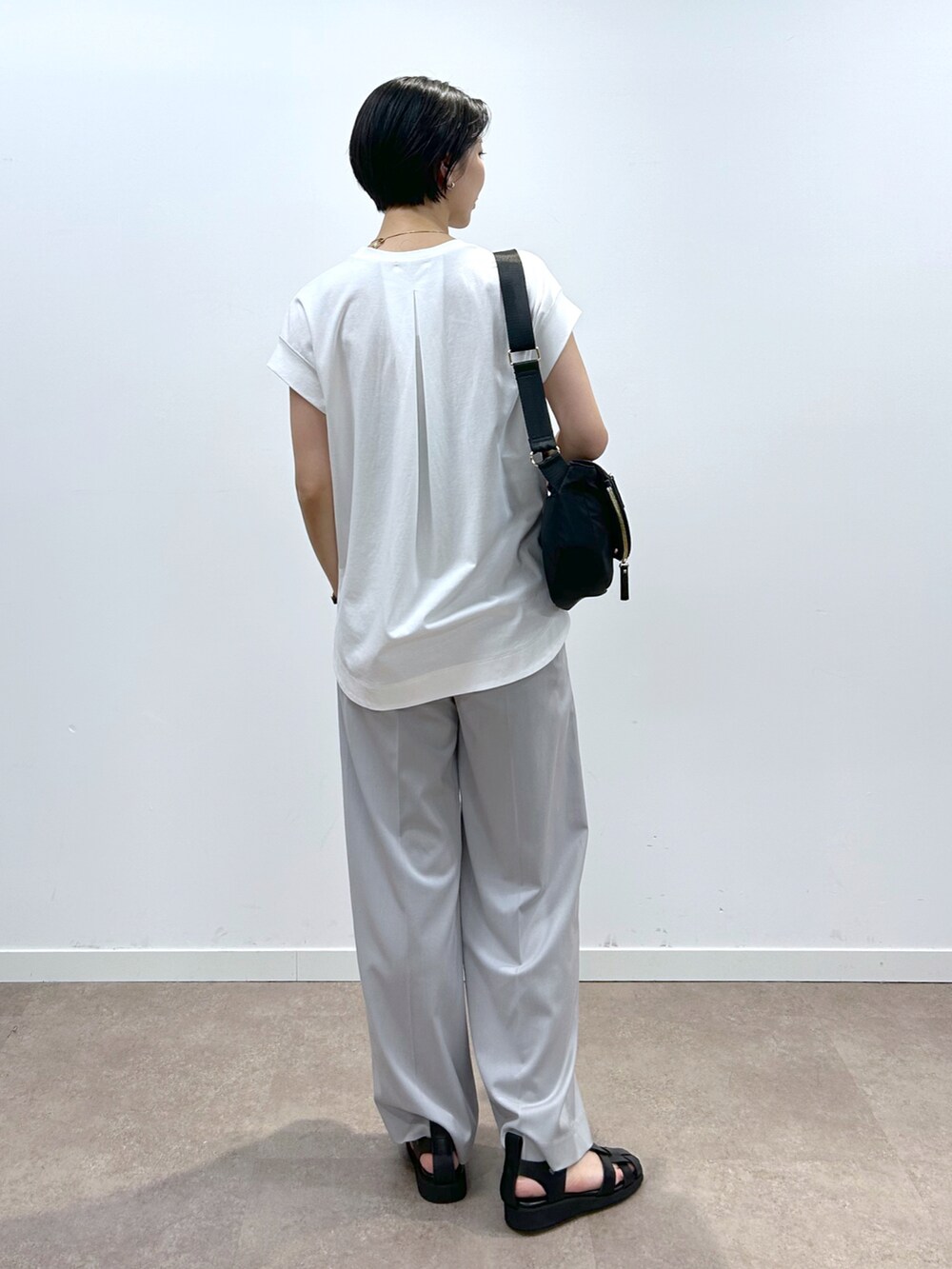 ブラック系のショルダーバッグ、ブラック系のサンダル、ホワイト系のTシャツ/カットソーを着用したレディースの春コーディネートの3枚目の写真