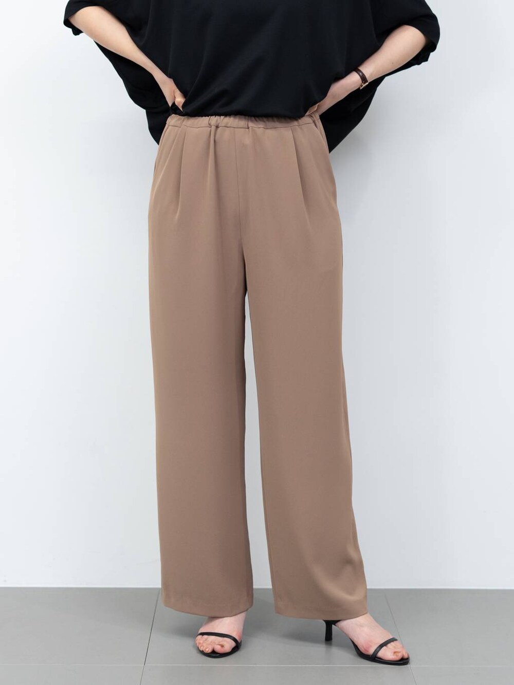 ブラック系のボストンバッグ、ブラウン系のスラックス、ブラック系のサンダルを着用したレディースの春コーディネートの4枚目の写真