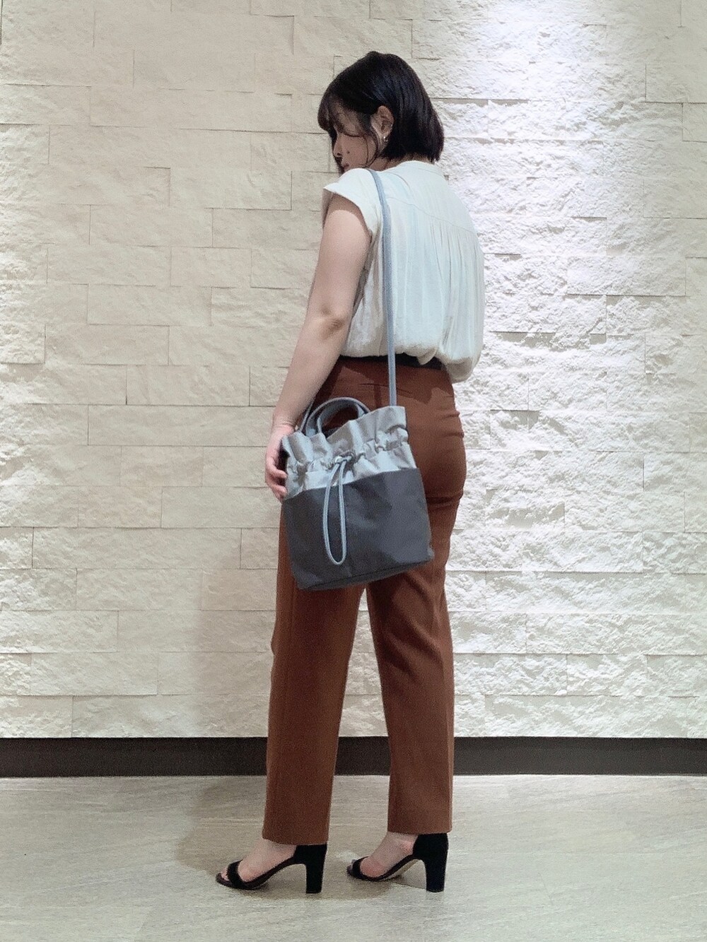 グレー系のショルダーバッグを着用したレディースの夏コーディネートの4枚目の写真