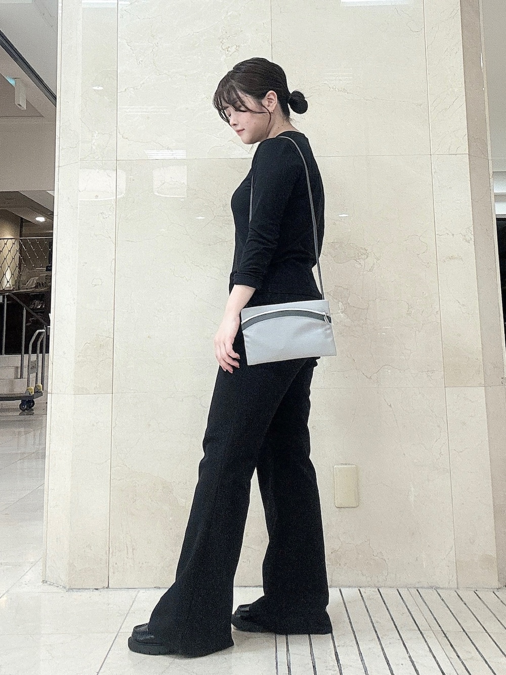 グレー系のショルダーバッグを着用したレディースの秋コーディネートの2枚目の写真