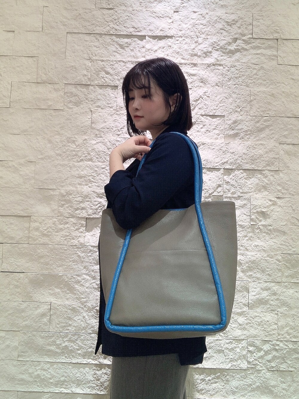 グレー系のトートバッグを着用したレディースの夏コーディネートの2枚目の写真