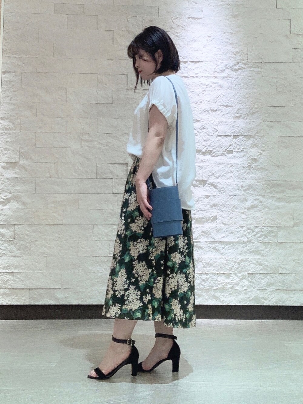 ブルー系のショルダーバッグを着用したレディースの夏コーディネートの2枚目の写真